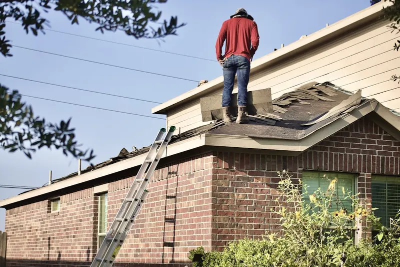 Professional roofer working on a residential roof in Camp Nashoba